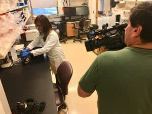 KLRN recording footage in a lab as Lab Personnel work