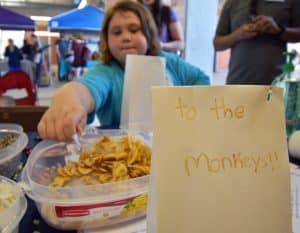 Girl next to snacks for the monkeys