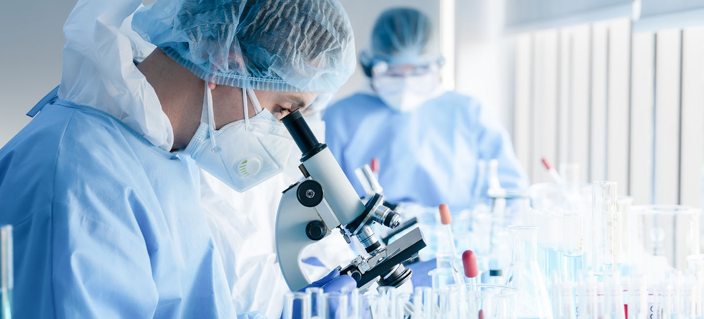 Scientist looking through microscope stock photo